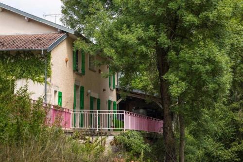 una casa con un balcone rosa e alberi di Jolie vache déguisée en fleurs, chambre d'hôte à Soulosse a Soulosse-sous-Saint-Élophe