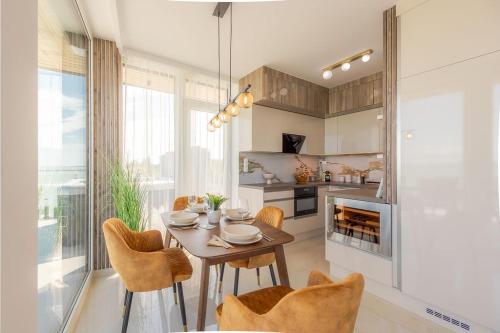 a dining room with a table and chairs in a kitchen at LelleMarine by BLTN Apartmanok Balatonlelle in Balatonlelle