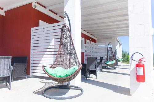 a hammock on a patio with chairs and a fire extinguisher at Tenuta Amostuni-Country House in Ostuni