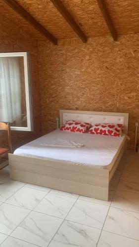 Un dormitorio con una cama con almohadas rojas. en Shtepi pushimi Ajla en Borsh