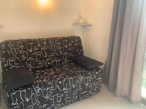 - un canapé noir avec des écritures blanches dans une chambre dans l'établissement Studio Marcu vue mer, à Porticcio
