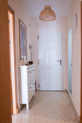 a hallway with a white door and a white cabinet at Kimba in Tarifa