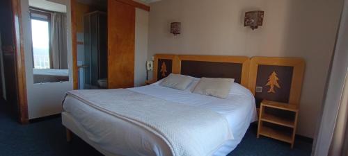 a bedroom with a large bed with white sheets at Le Llaret in Les Angles