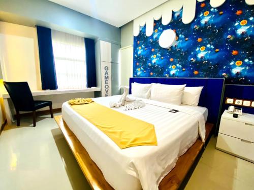 a bedroom with a large bed with a christmas wall at Luminor Hotel Banyuwangi By WH in Banyuwangi