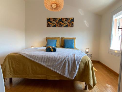 - une chambre avec un lit avec un animal rembourré dans l'établissement Gite de la rivière avec patio et parking centre ville, au Mans