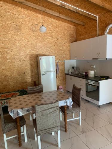 kuchnia ze stołem, krzesłami i lodówką w obiekcie Shtepi pushimi Ajla w mieście Borsh