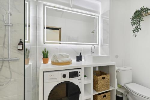 La salle de bains est pourvue d'un lavabo et d'un lave-linge sous un miroir. dans l'établissement Le Beausoleil Duplex (Clim - Wifi - Netflix), à Marseille