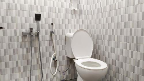 a bathroom with a toilet and a shower at Omah Leren Mitra RedDoorz near Gembiraloka Zoo Yogyakarta in Timuran
