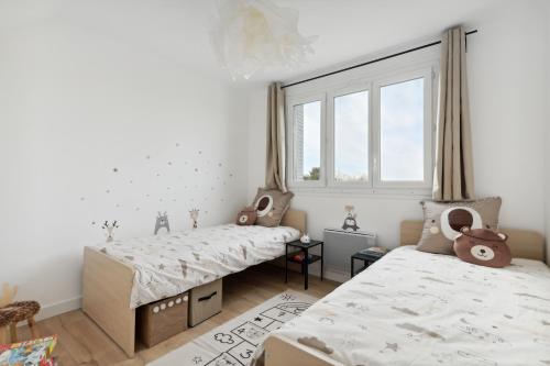 une chambre avec deux lits et une fenêtre dans l'établissement Le Beausoleil Duplex (Clim - Wifi - Netflix), à Marseille