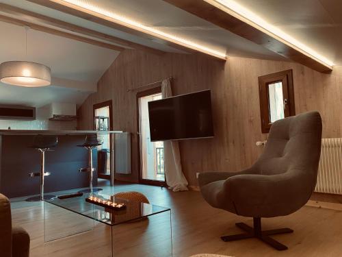 a living room with a chair and a television at Terra-Beka Lodge in La Chapelle-dʼAbondance
