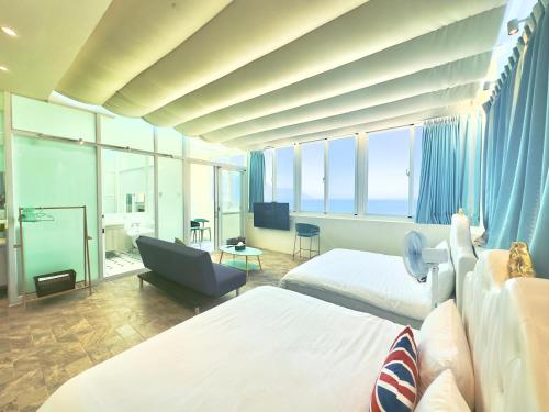 une chambre d'hôtel avec deux lits et une chaise dans l'établissement Go to Qixingtan Seaview B&B, à Dahan