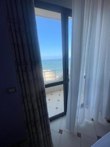 a room with a window with a view of the ocean at Hotel Ferrara in Durrës