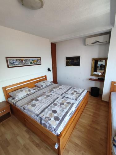 Villa Dudinka في أوخريد: غرفة نوم بسرير خشبي مع أرضية خشبية