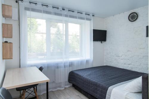 Schlafzimmer mit einem Bett, einem Fenster und einem Schreibtisch in der Unterkunft MYFREEDOM Апартаменти метро Берестейська in Kiew