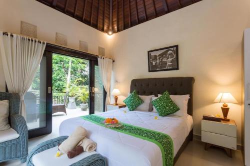 Bakti Villa في أوبود: غرفة نوم مع سرير عليه صينية
