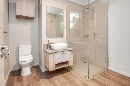 a bathroom with a toilet and a sink and a shower at The Galleries Serviced Apartments in Rosebank in Johannesburg