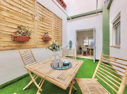 a patio with a wooden table and two chairs at Palm Street Apartment in Puerto de la Cruz