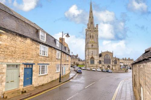 an empty street with a church and a tower at Victorian townhouse - Stamford centre - 2 big bedrooms, living room kitchen etc tastefully decorated in Stamford