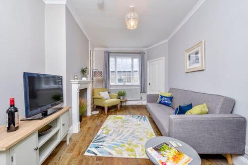 a living room with a couch and a tv at Victorian townhouse - Stamford centre - 2 big bedrooms, living room kitchen etc tastefully decorated in Stamford