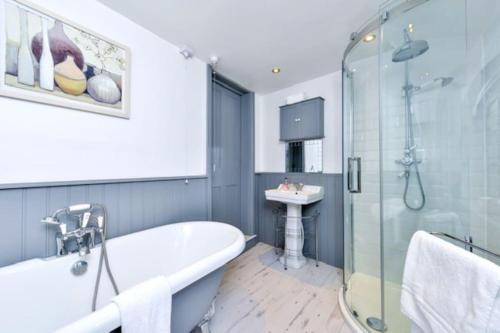 La salle de bains est pourvue d'une baignoire et d'un lavabo. dans l'établissement Victorian townhouse - Stamford centre - 2 big bedrooms, living room kitchen etc tastefully decorated, à Lincolnshire