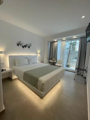 a bedroom with a large bed and a large window at Merovigliosso in Imerovigli