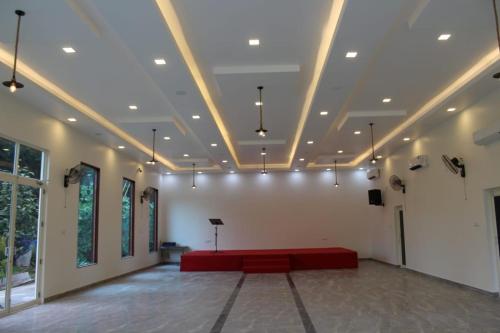 a large room with a red couch in the middle at LUNAPIENA RESORTS in Tiruvankod
