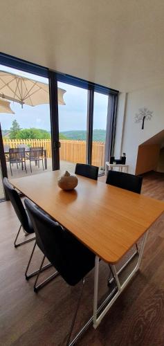 a large wooden table in a room with chairs at La Maison du Sabotier in Custinne