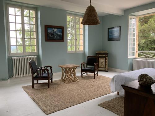 1 dormitorio con 1 cama, 2 sillas y mesa en La Téoulère du Bas, en Laguian-Mazoux