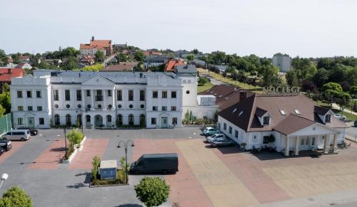 an aerial view of a large white building with a parking lot at Arkadia in Radziejów