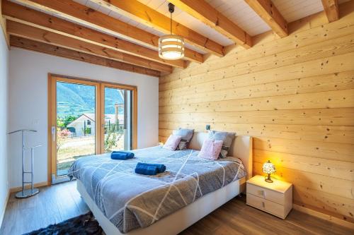 ein Schlafzimmer mit einem Bett mit einer Holzwand in der Unterkunft Villa mitoyenne proche des bains in Saillon