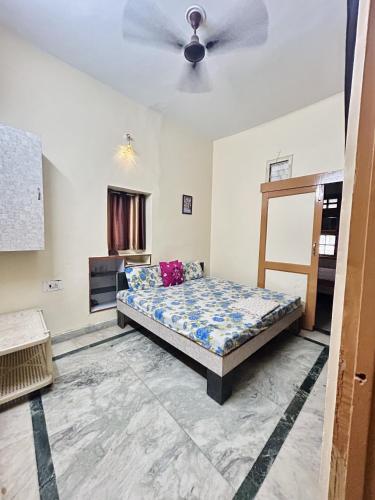 a bedroom with a bed and a ceiling fan at Namaste Amritsar Homestay in Amritsar
