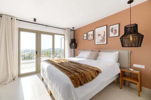 1 dormitorio con cama grande y ventana grande en Villa Maria - Luxury Getaway, en Ses Paisses