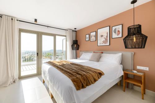 a bedroom with a large bed and a large window at Villa Maria - Luxury Getaway in Ses Paisses