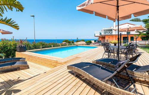 a deck with chairs and an umbrella and a pool at MaryWilliam in Agropoli