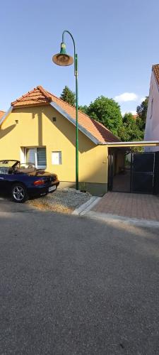 a car parked in front of a yellow house at Sunny House in Netolice