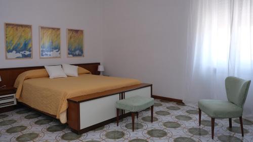 a bedroom with a bed and a chair at Casa Busciana in Olmedo