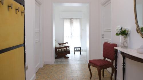 a hallway with a red chair and a table at Casa Busciana in Olmedo