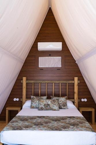 a bedroom with a bed in a tent at Casas Rurales el Nogalejo Setenil in Setenil
