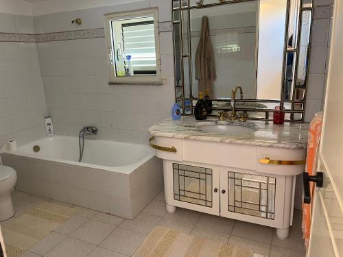 y baño con bañera, lavamanos y bañera. en Casa Vacanze M en Bagnara Calabra