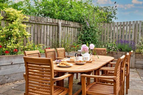 una mesa de madera y sillas en un jardín en Finest Retreats - Quarry Lodge, en Wigton