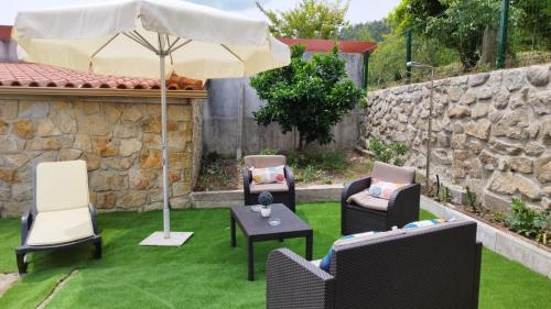 的住宿－Casa dos Devezas，庭院配有椅子和遮阳伞,位于草地上