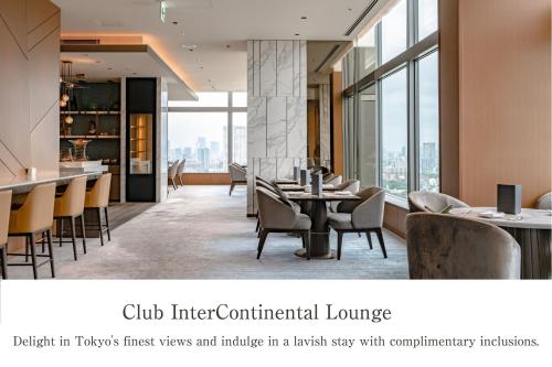 un restaurante con mesas, sillas y ventanas en The Strings by InterContinental, Tokyo, an IHG Hotel, en Tokio