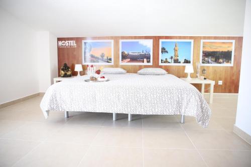 1 dormitorio con 1 cama grande con colcha blanca en Zambeachouse - Hostel Paradise, en Areia Branca