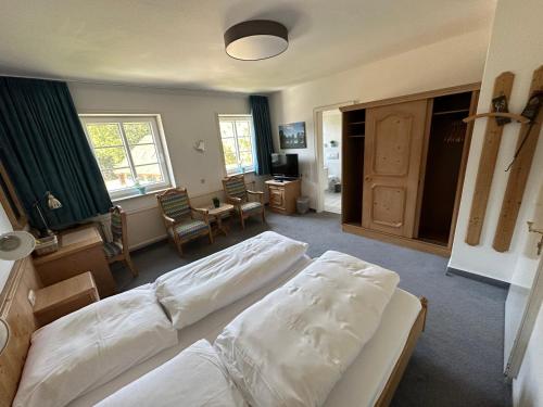 a bedroom with two beds and a living room at Gasthof Menke in Niederhaverbeck