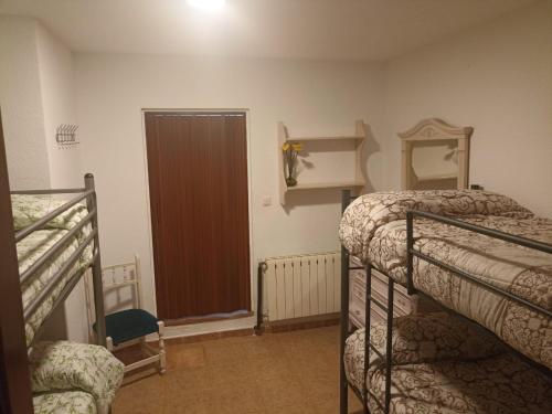 a room with two bunk beds and a door at Hostal El Desvío in Sierra Nevada