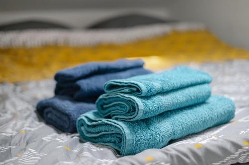 uma pilha de toalhas azuis sentadas numa cama em Studio Strasbourg centre em Estrasburgo