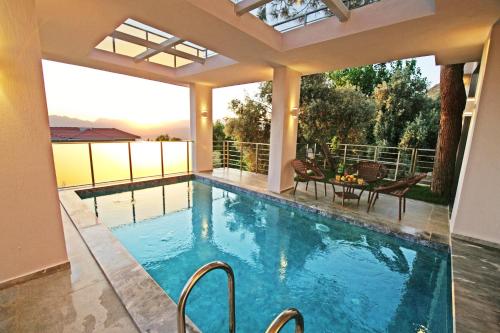 a swimming pool with a view of a house at Villa With a Private Heated Pool, Jacuzzi, Overlooking Spectacular Views Of The Sea in Kas