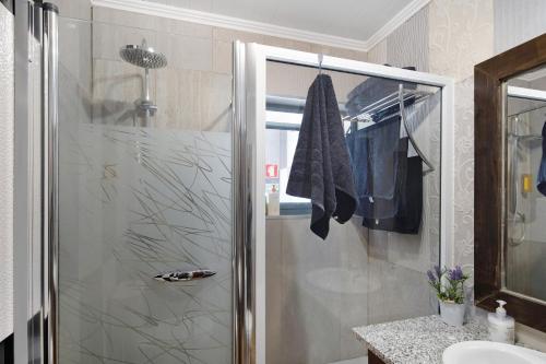 a shower with a glass door in a bathroom at Alojamento do Rosário in Lagoa