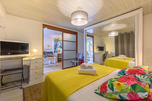 une chambre d'hôtel avec deux lits et une télévision dans l'établissement Sous les Palmiers - Charmant Appartement avec terrasse, à Vannes