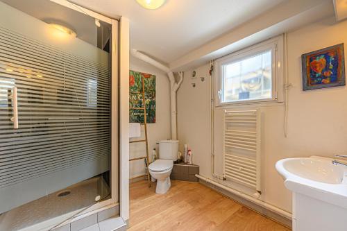ein Bad mit einem WC, einem Waschbecken und einem Fenster in der Unterkunft Sous les Palmiers - Charmant Appartement avec terrasse in Vannes